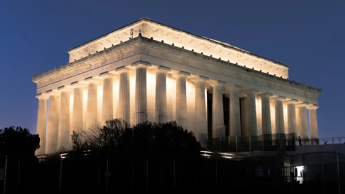 Lincoln Memorial illuminated at night with visitors exploring the historic site in Washington DC