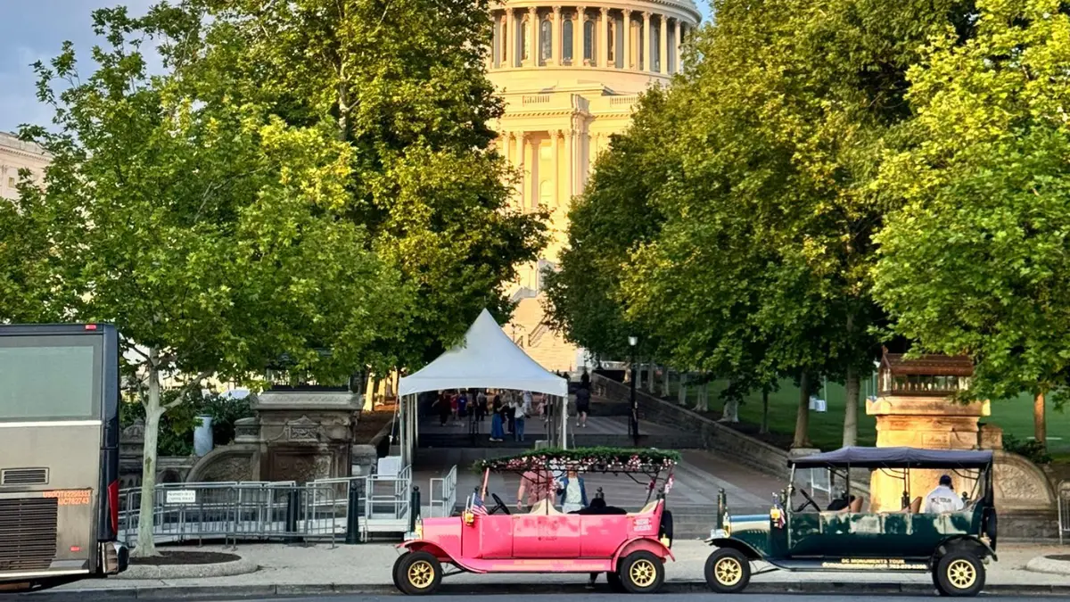 Vintage electric tour vehicle driving past iconic Washington DC monuments